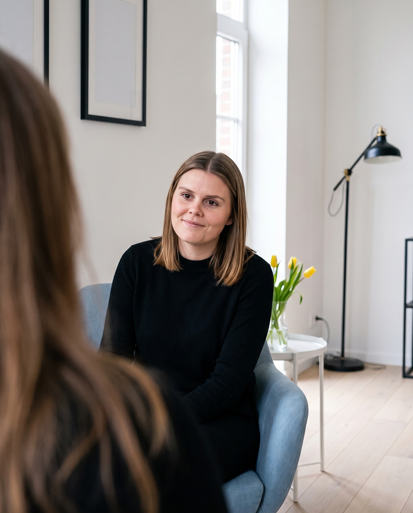 Louise luistert in de blauwe zetel naar een cliënte